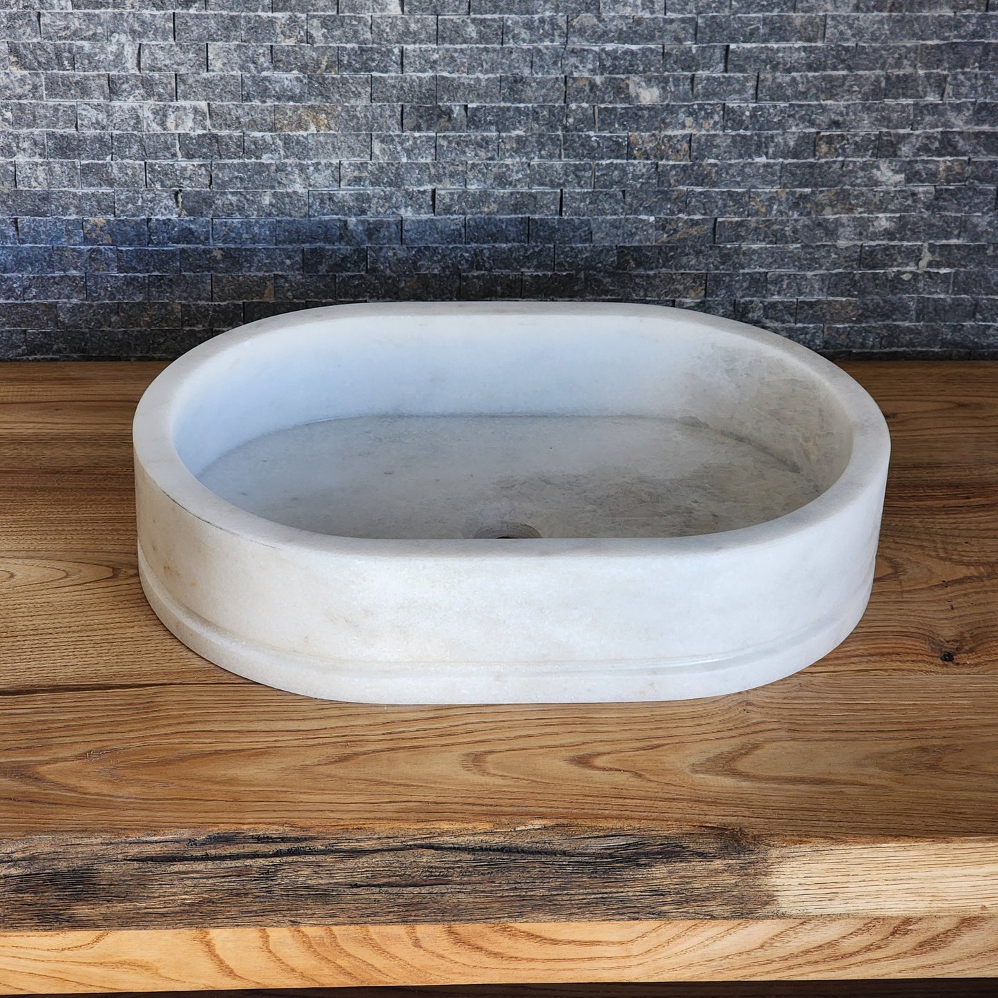 Marble basin on a wooden surface with a textured background