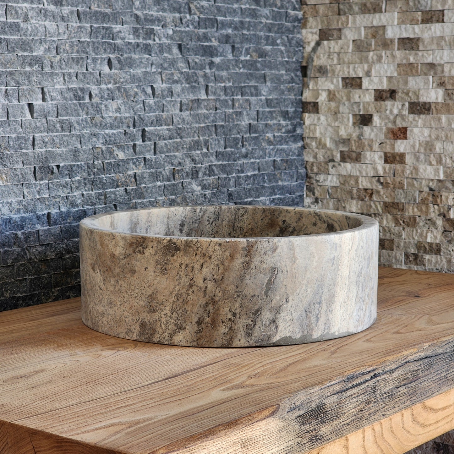 Norhew luxury round dark grey marble vessel sink featuring dramatic charcoal and white crystalline veining on a warm wood vanity.