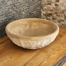 Switch Norhew luxury round travertine vessel sink featuring a hand-chiseled raw exterior and a smooth honed interior on a rustic wood vanity. 3 image