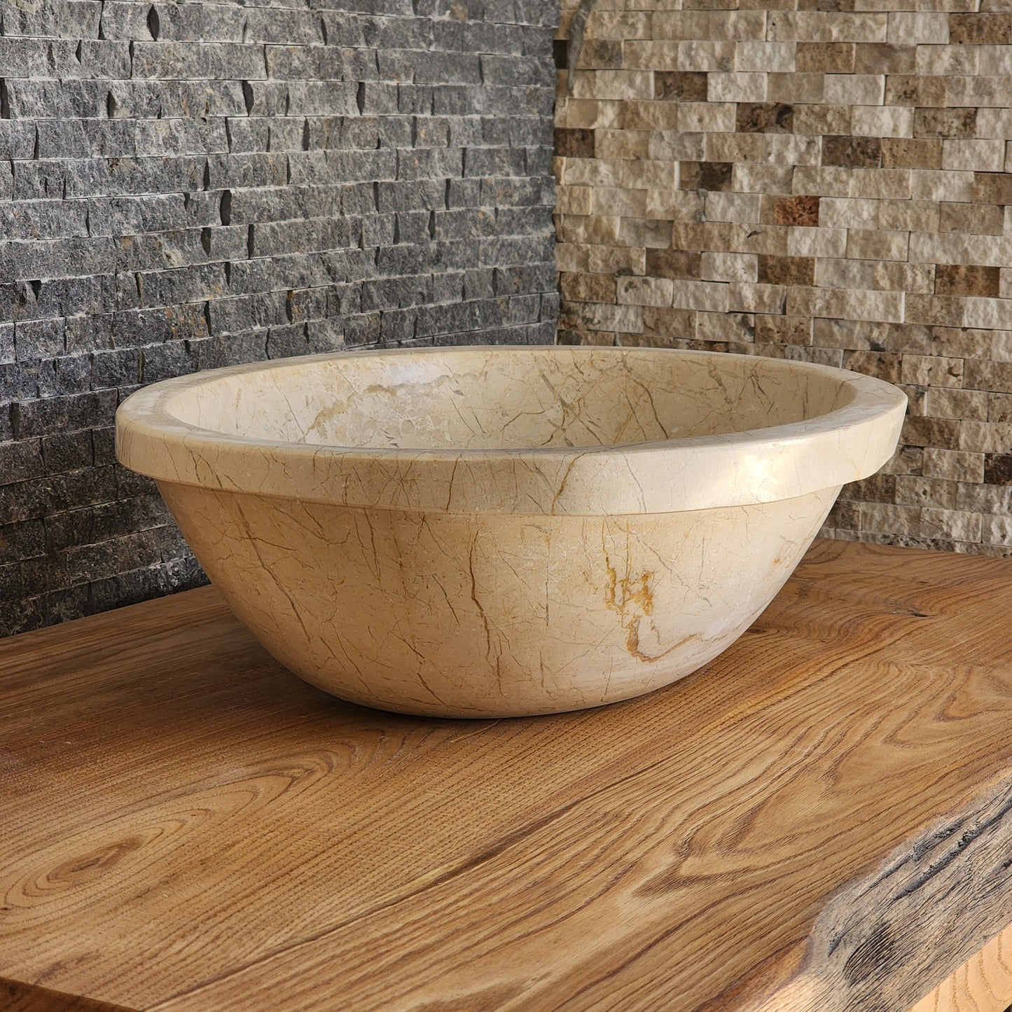 Norhew luxury oval beige breccia marble vessel sink with a classic flared rim and intricate natural veining on a wooden vanity.