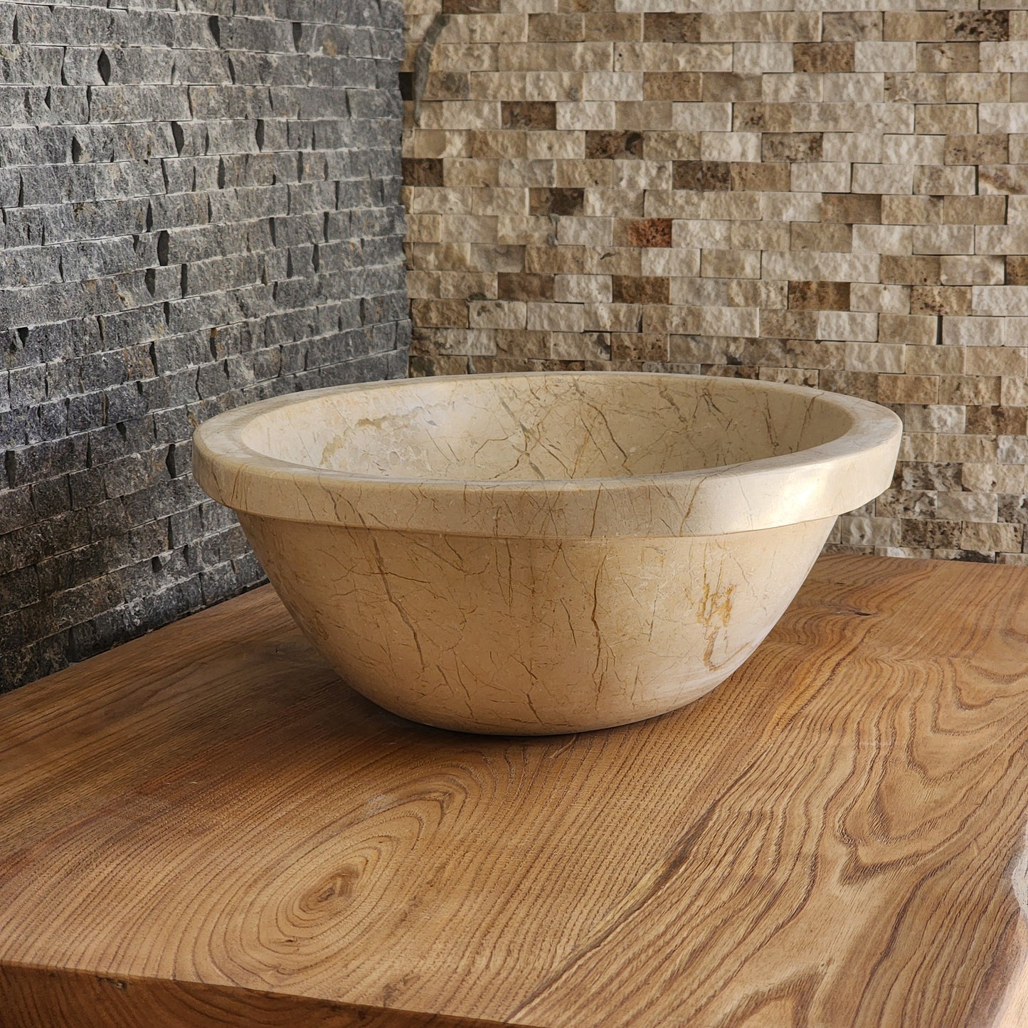 Norhew luxury oval beige breccia marble vessel sink with a classic flared rim and intricate natural veining on a wooden vanity.
