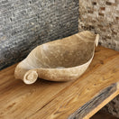 Switch Norhew luxury beige marble boat-shaped vessel sink with hand-carved scroll spiral edges on a natural oak vanity. 3 image
