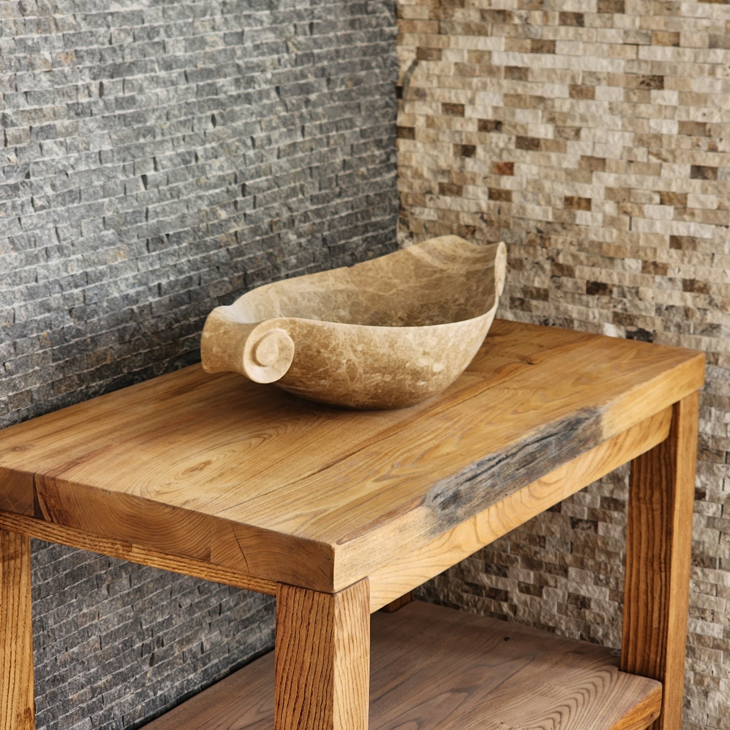 Norhew luxury beige marble boat-shaped vessel sink with hand-carved scroll spiral edges on a natural oak vanity.