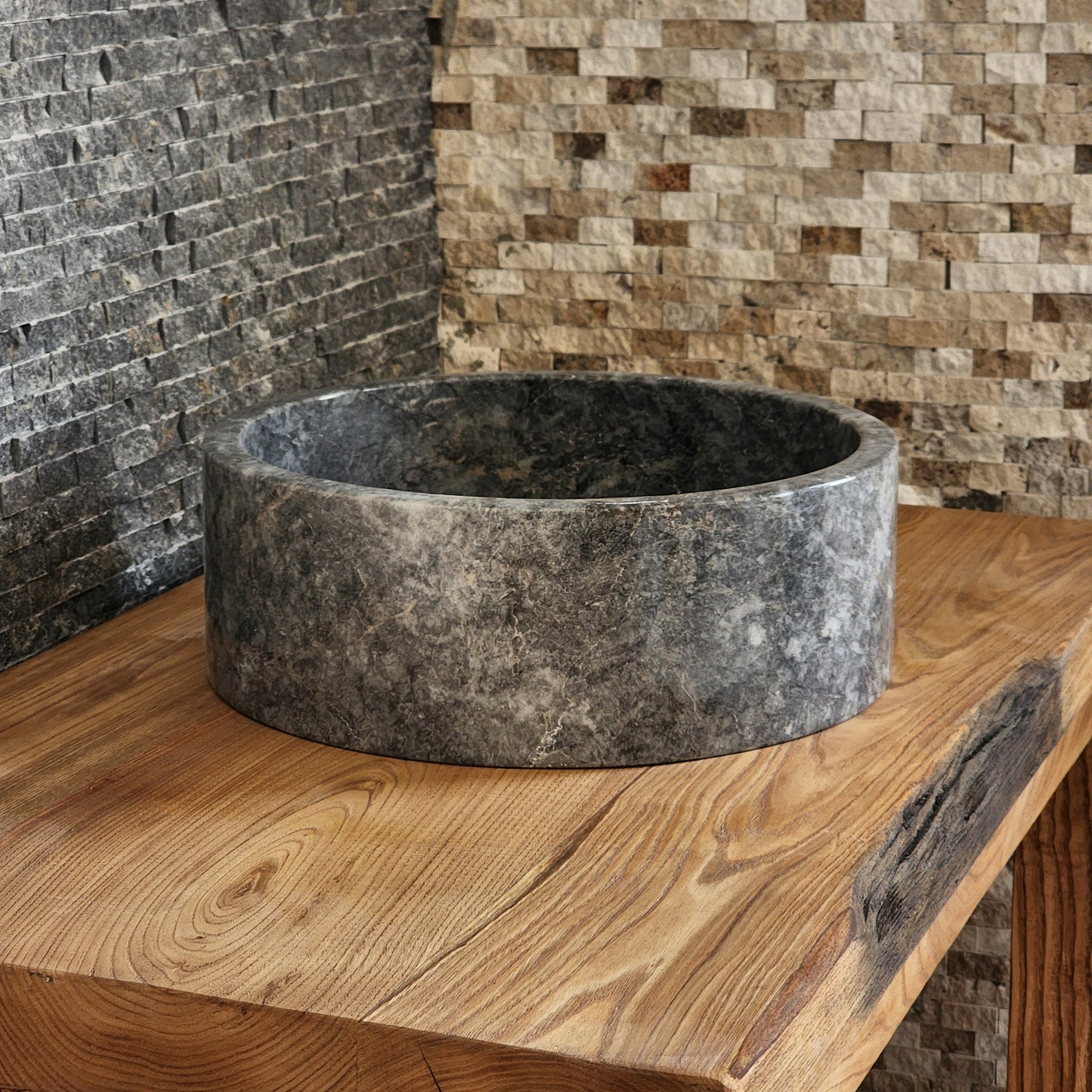 Norhew luxury round gray storm marble vessel sink with dramatic charcoal and white crystalline veining on a rustic wood vanity.