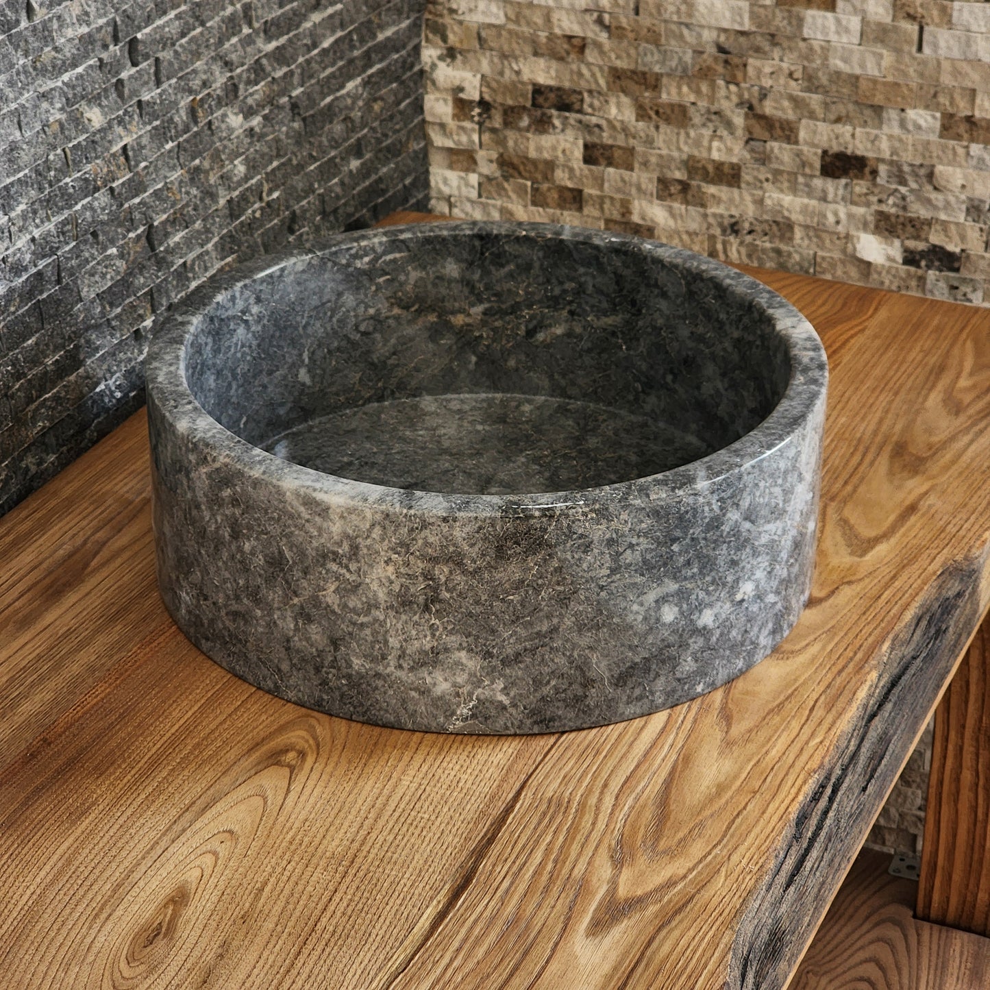 Norhew luxury round gray storm marble vessel sink with dramatic charcoal and white crystalline veining on a rustic wood vanity.