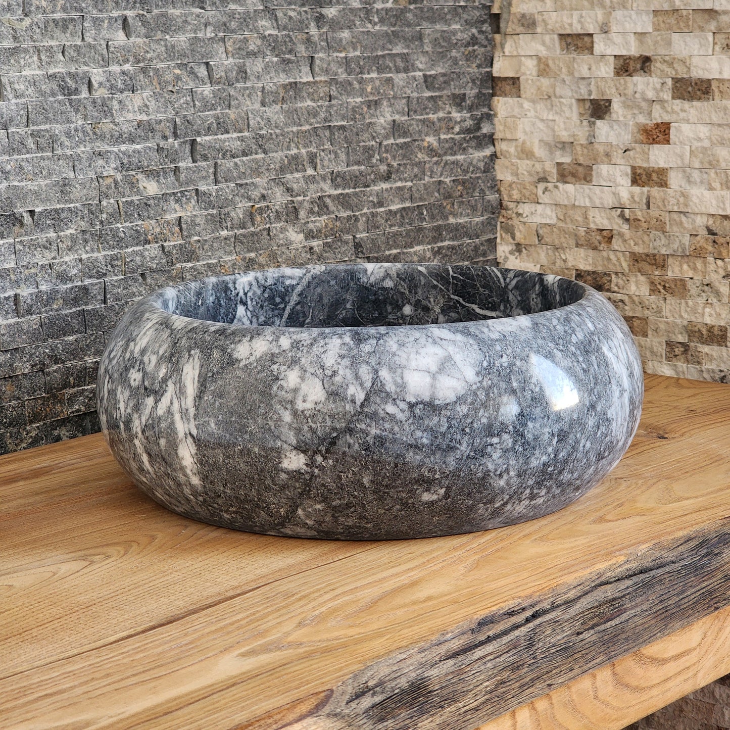 Norhew luxury round gray storm marble vessel sink with dramatic charcoal and white crystalline veining on a rustic oak vanity.