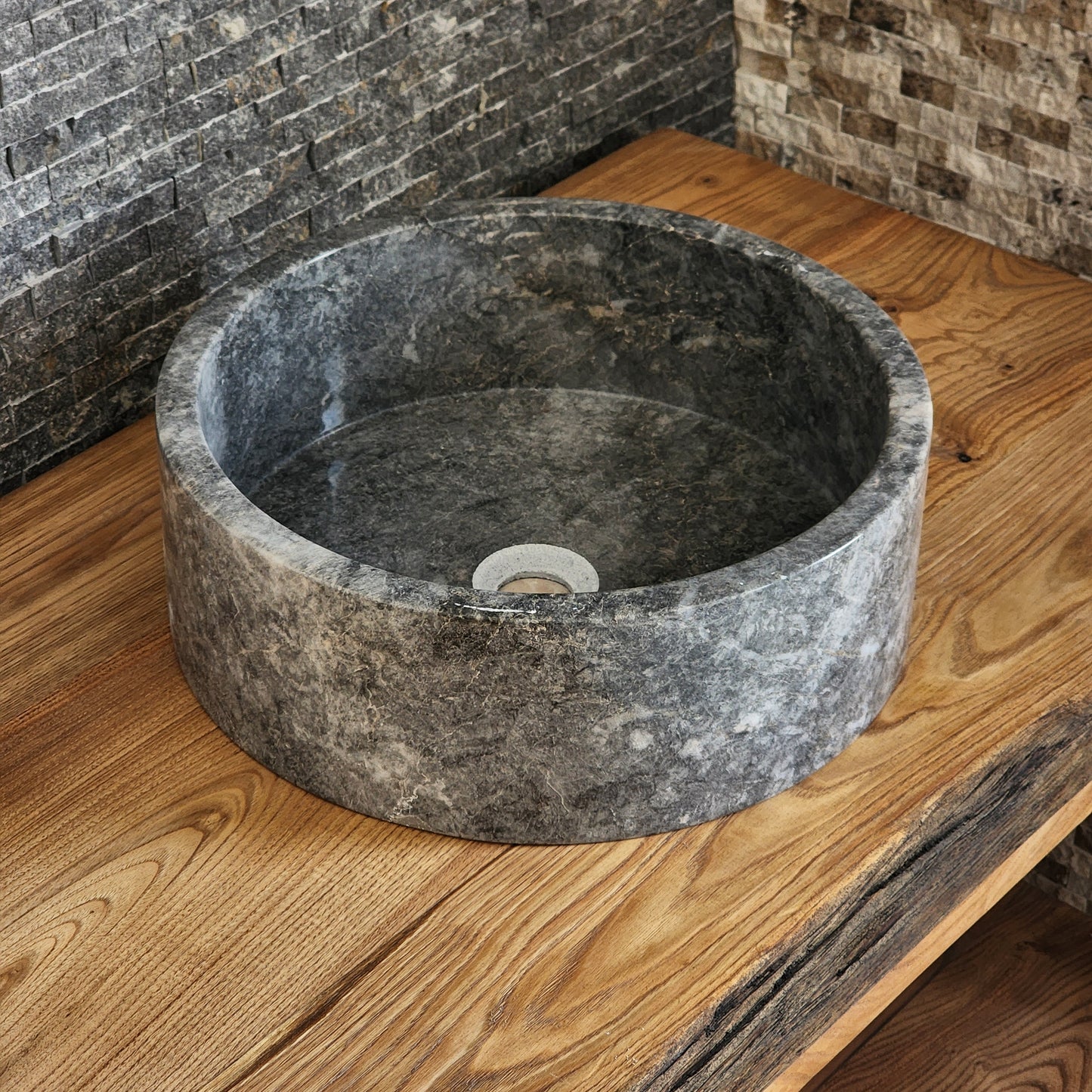 Norhew luxury round gray storm marble vessel sink with dramatic charcoal and white crystalline veining on a rustic wood vanity.