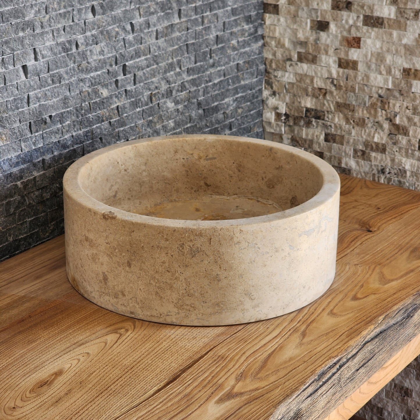 Norhew luxury organic natural-shape travertine vessel sink with a weathered split-face exterior and a smooth honed interior.