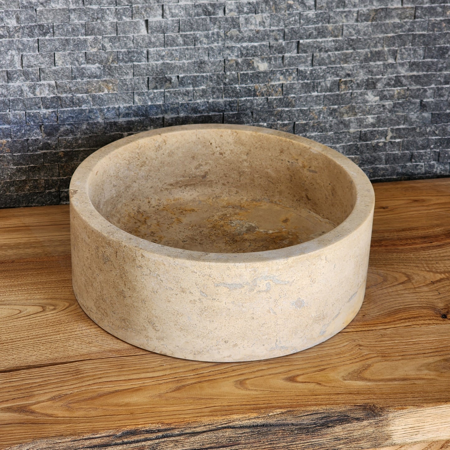 Norhew luxury organic natural-shape travertine vessel sink with a weathered split-face exterior and a smooth honed interior.