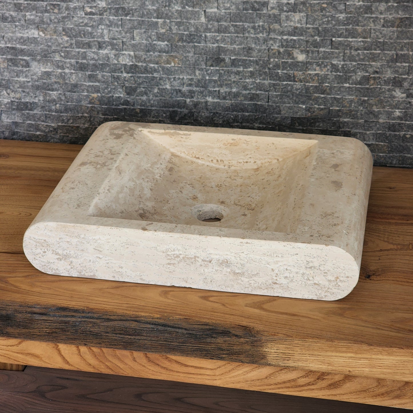 Norhew luxury rectangular travertine vessel sink with a sloped infinity interior and smooth radius-curved edges on a wooden vanity.