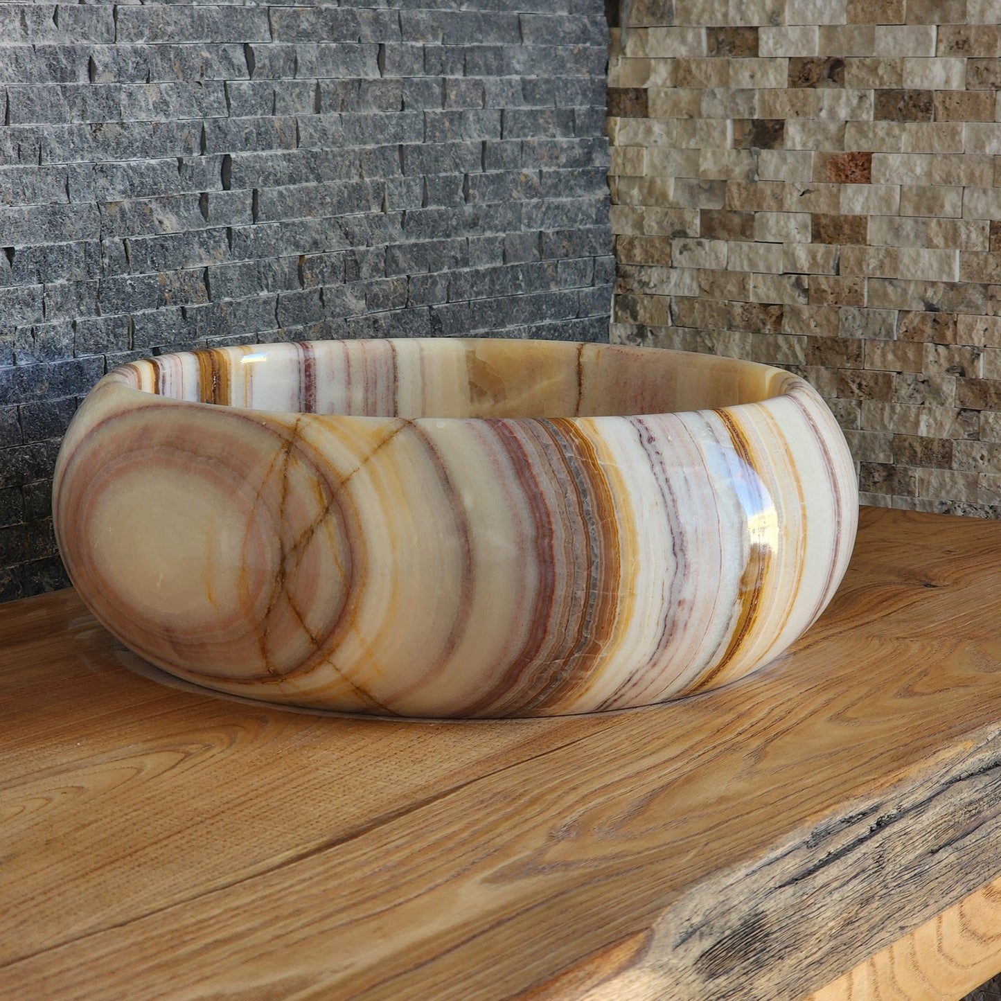 Decorative stone bowl with layered patterns on a wooden surface