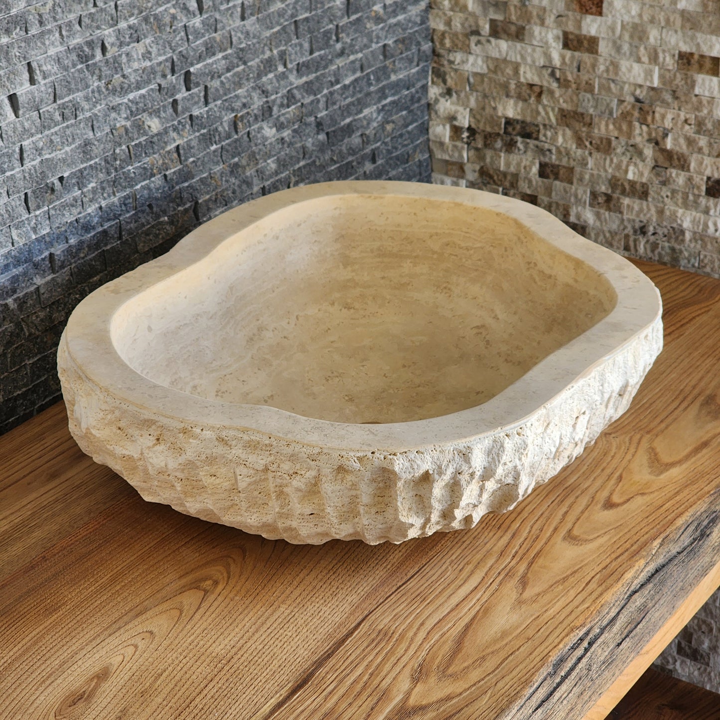 Norhew luxury organic oval travertine vessel sink with a hand-chiseled raw exterior and a smooth honed interior on a solid wood vanity