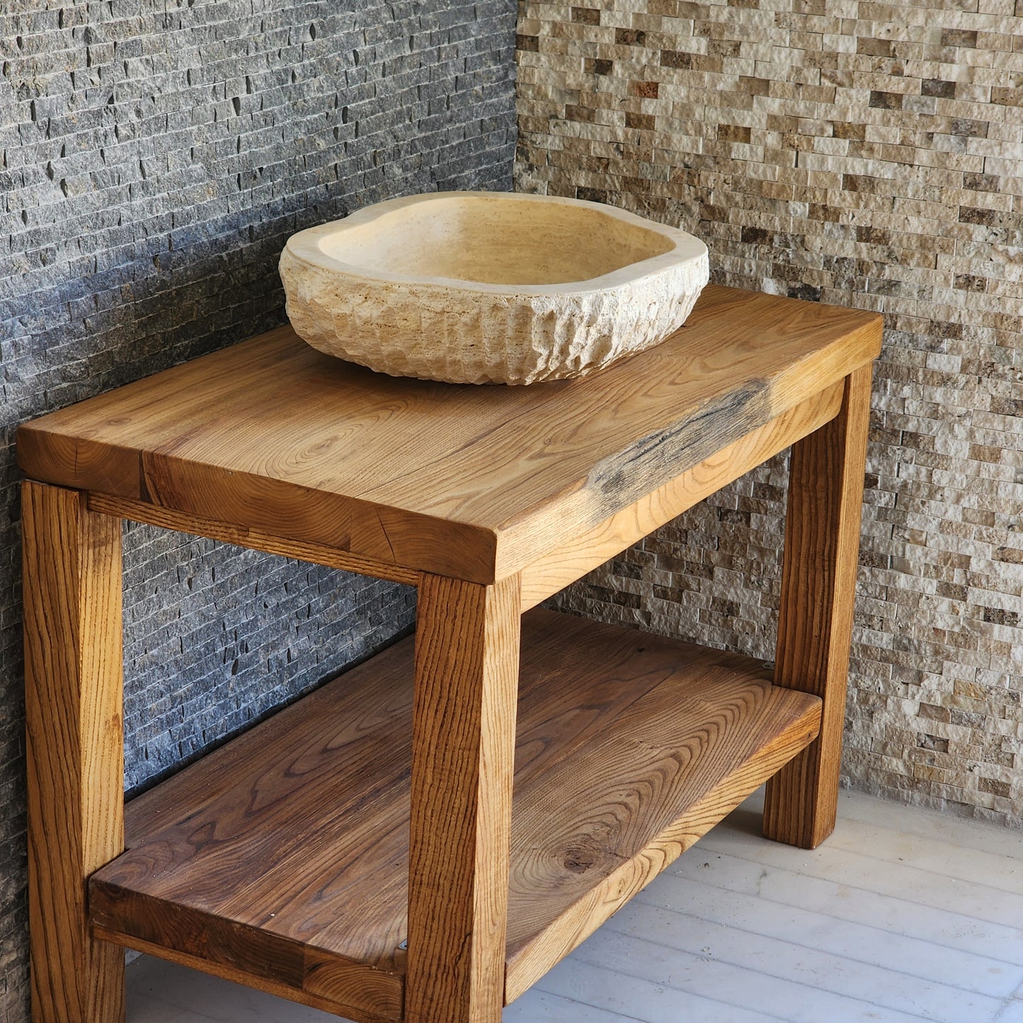Norhew luxury organic oval travertine vessel sink with a hand-chiseled raw exterior and a smooth honed interior on a solid wood vanity