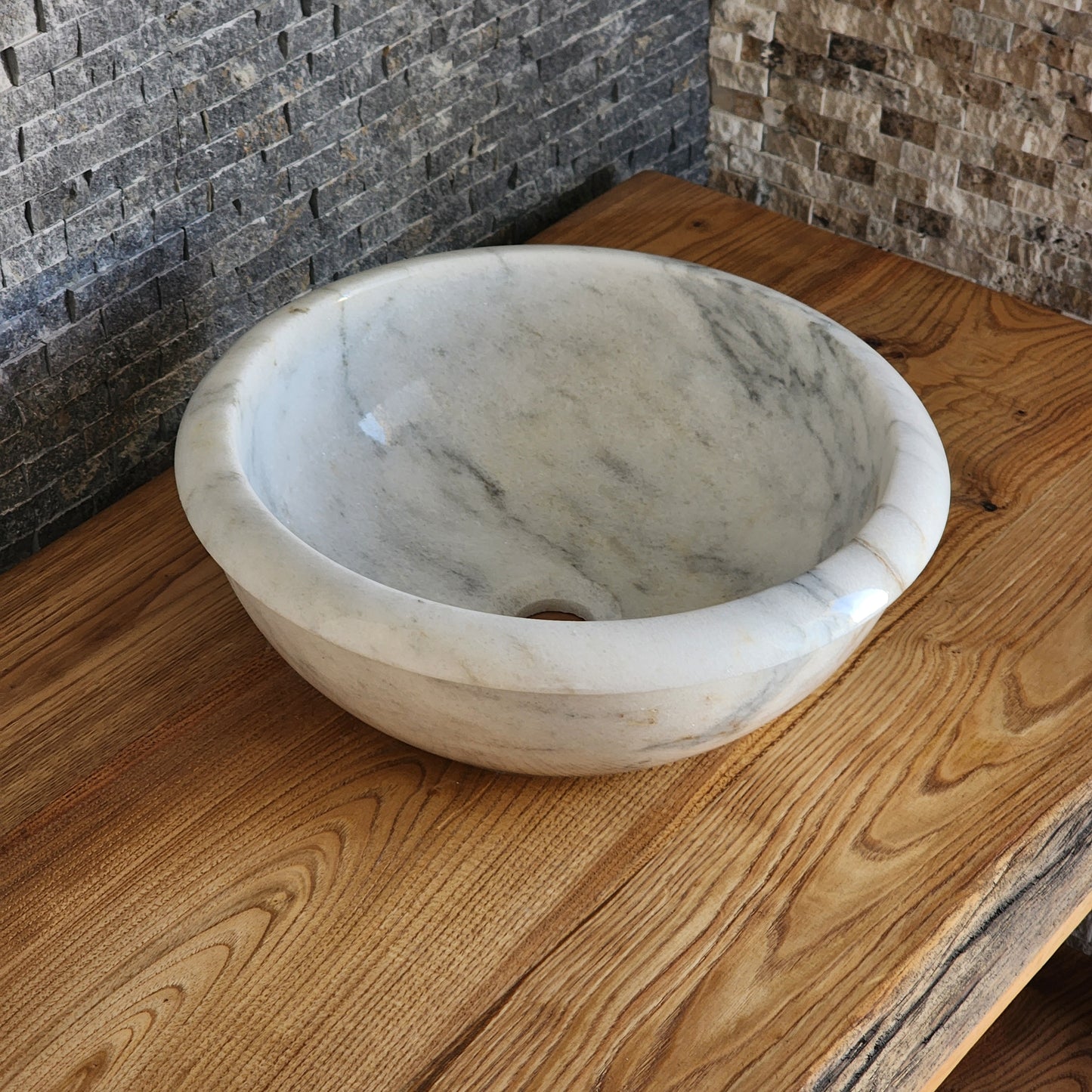 Norhew luxury white marble oval vessel sink with natural grey veining and a tiered base on a rustic wood vanity