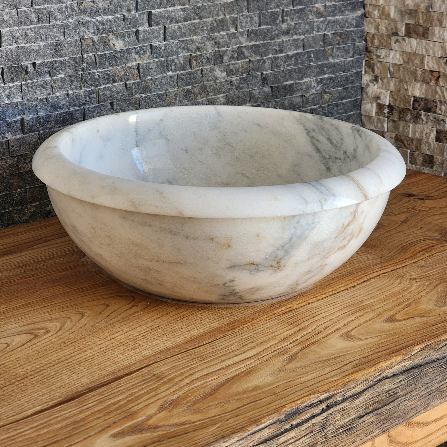 Norhew luxury white marble oval vessel sink with natural grey veining and a tiered base on a rustic wood vanity