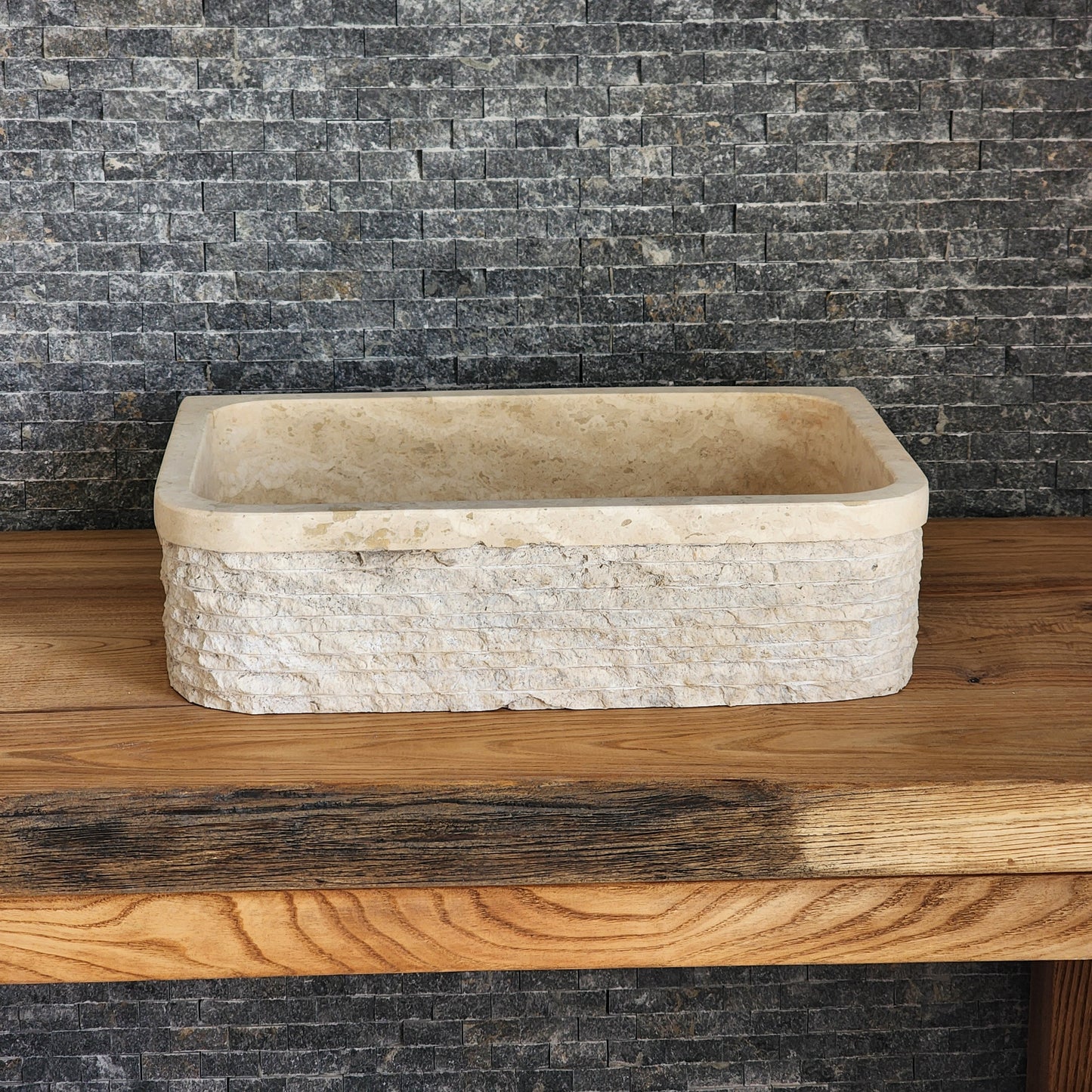 Norhew luxury D-shaped solid travertine vessel sink with a hand-chiseled texture on both the curved front and flat back side.
