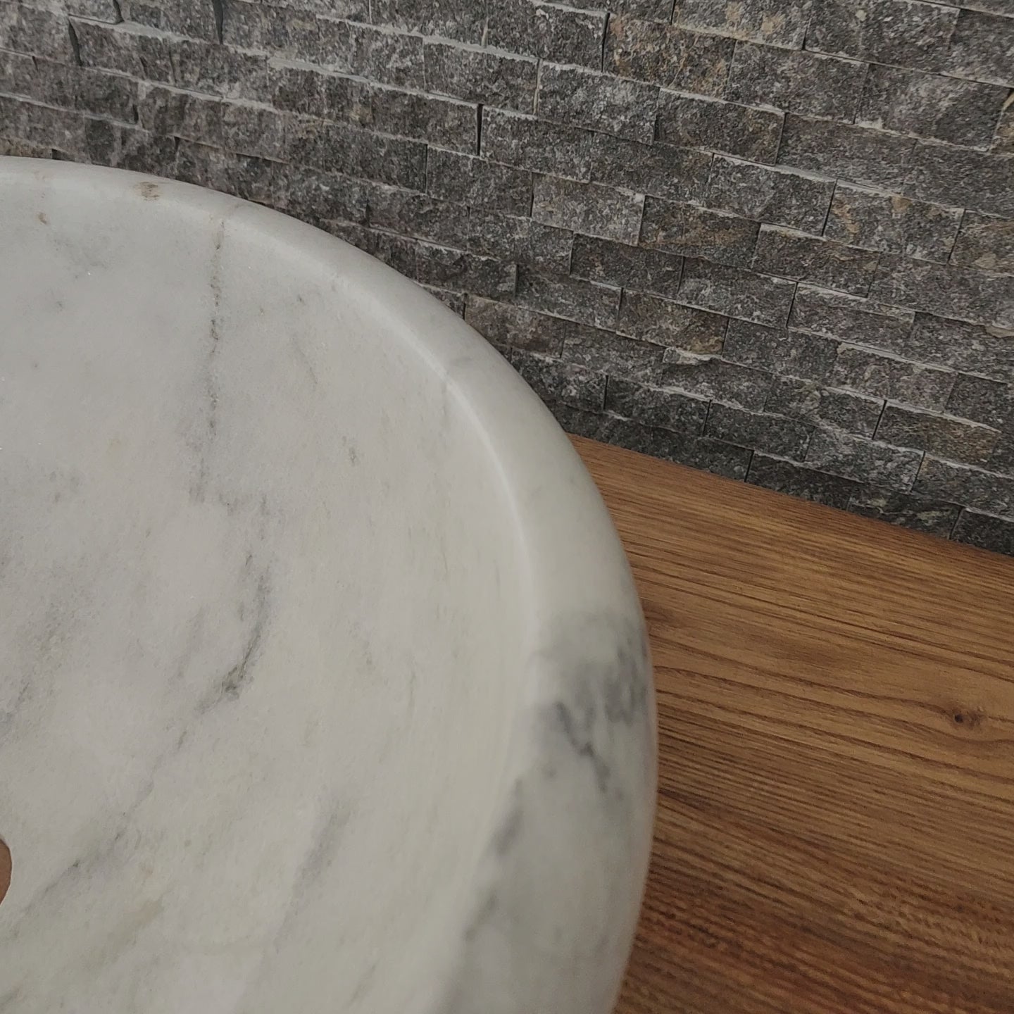 Norhew luxury white marble oval vessel sink with natural grey veining and a tiered base on a rustic wood vanity