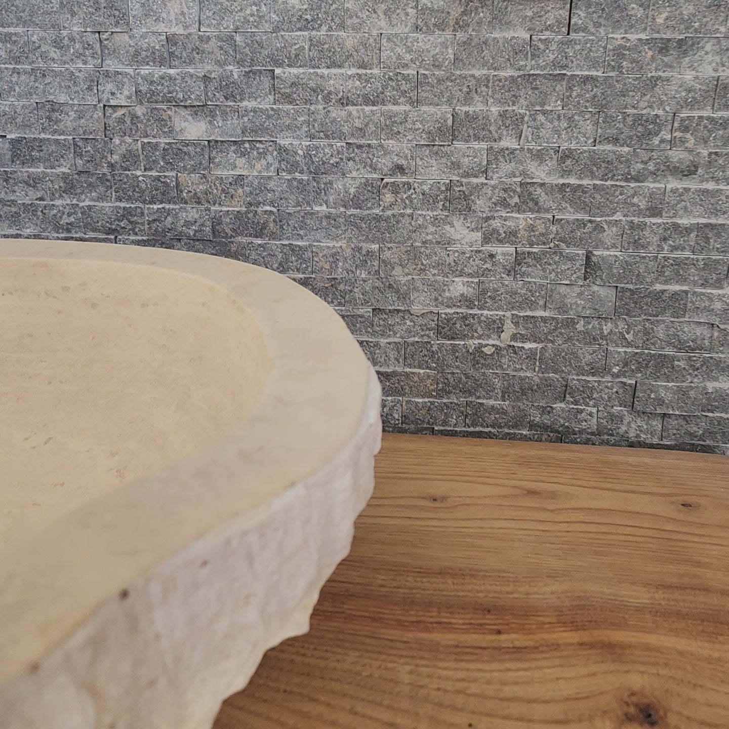 Norhew luxury organic oval travertine vessel sink with a hand-chiseled raw exterior and a smooth honed interior on a solid wood vanity