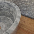 Switch High-walled cylindrical marble vessel sink with grey veining on wood vanity. 2 image