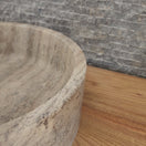 Switch Norhew luxury round dark grey marble vessel sink featuring dramatic charcoal and white crystalline veining on a warm wood vanity. 2 image