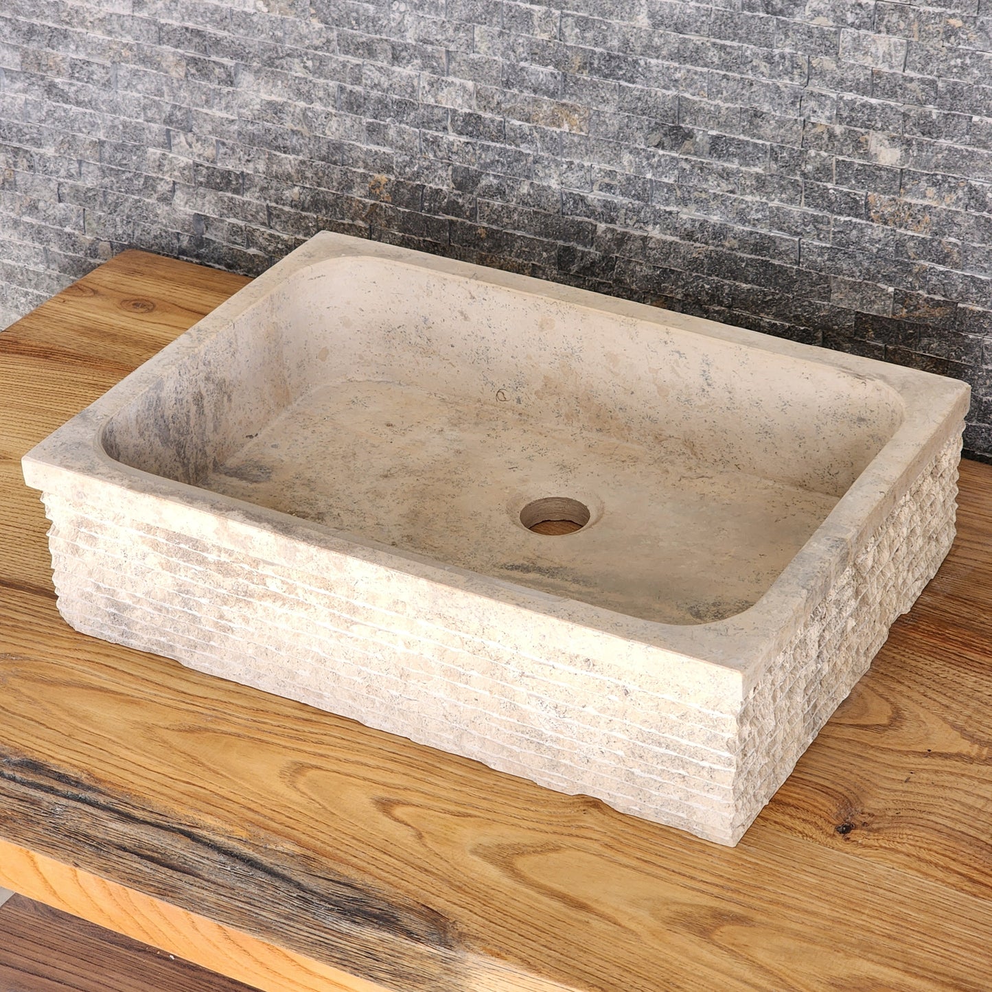 Norhew luxury rectangular travertine vessel sink featuring a hand-chiseled raw stone exterior and a smooth honed interior on a solid wood vanity.