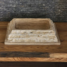 Switch Norhew luxury rectangular travertine vessel sink featuring a chiseled raw stone exterior and a smooth honed interior on a wooden vanity. 3 image
