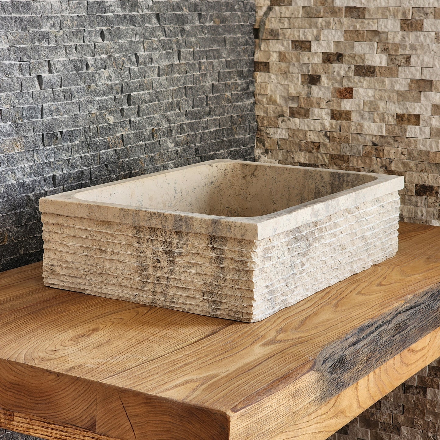 Norhew luxury rectangular travertine vessel sink featuring a hand-chiseled raw stone exterior and a smooth honed interior on a solid wood vanity.