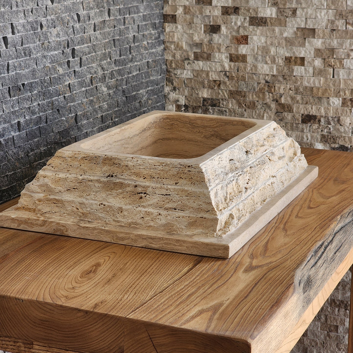 Norhew luxury rectangular travertine vessel sink featuring a chiseled raw stone exterior and a smooth honed interior on a wooden vanity.
