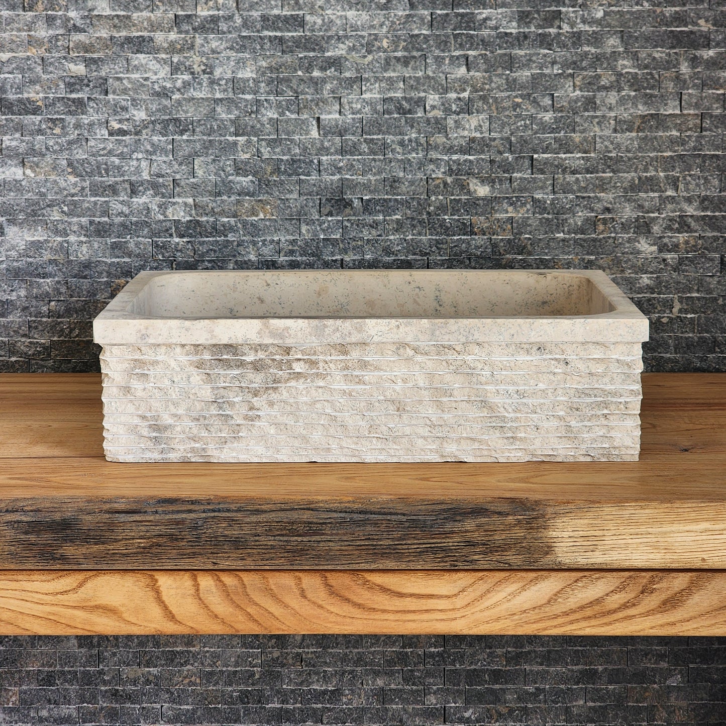 Norhew luxury rectangular travertine vessel sink featuring a hand-chiseled raw stone exterior and a smooth honed interior on a solid wood vanity.
