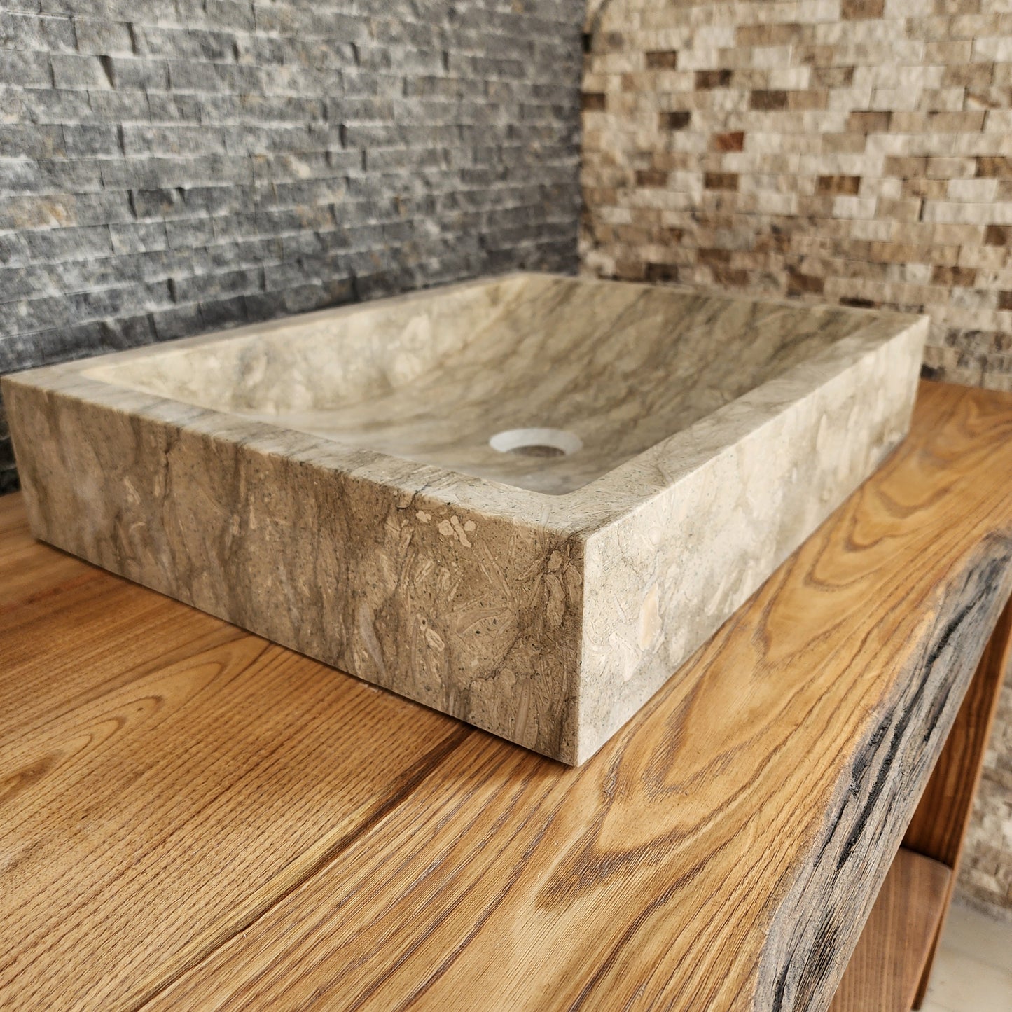 Norhew luxury rectangular marble vessel sink with extraordinary wavy olive and charcoal mineral veining on a light wood vanity.
