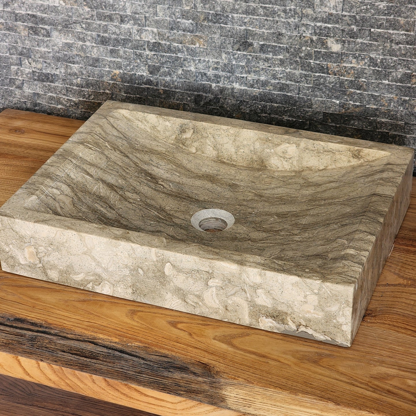 Norhew luxury rectangular marble vessel sink with extraordinary wavy olive and charcoal mineral veining on a light wood vanity.