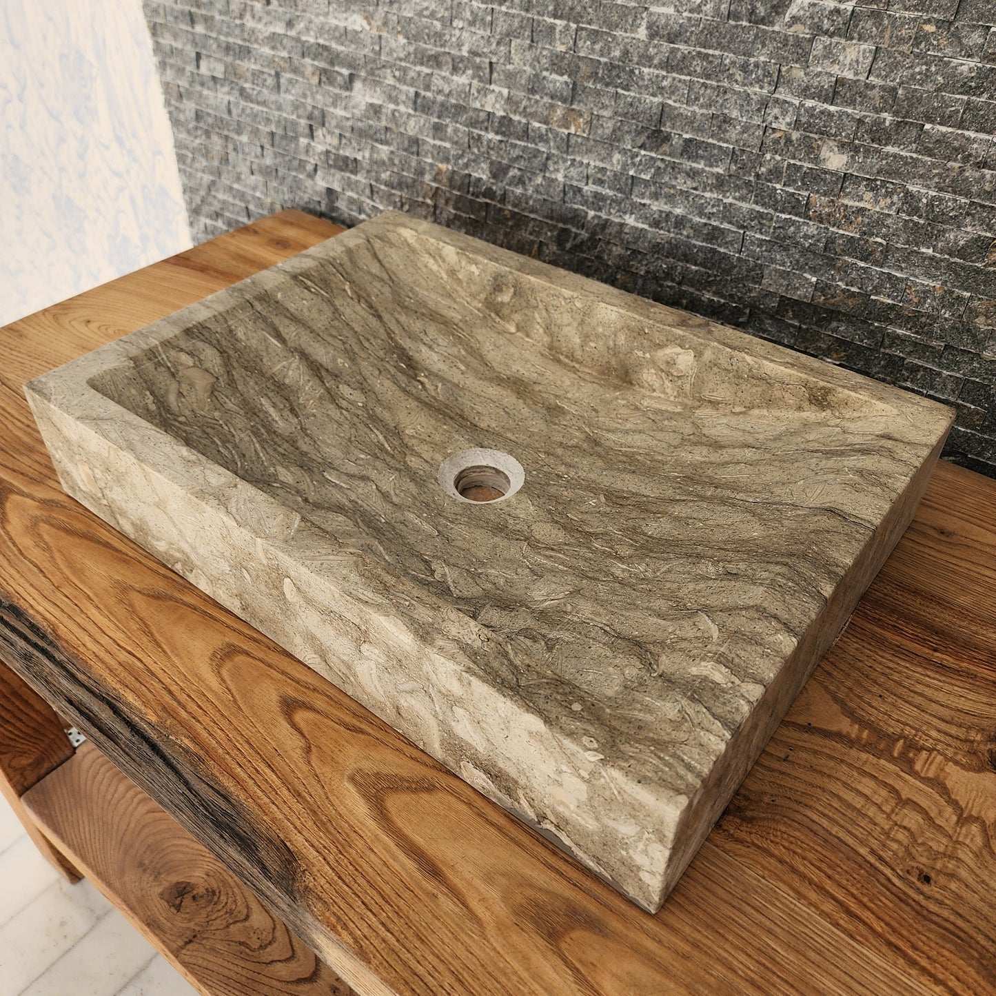 Norhew luxury rectangular marble vessel sink with extraordinary wavy olive and charcoal mineral veining on a light wood vanity.