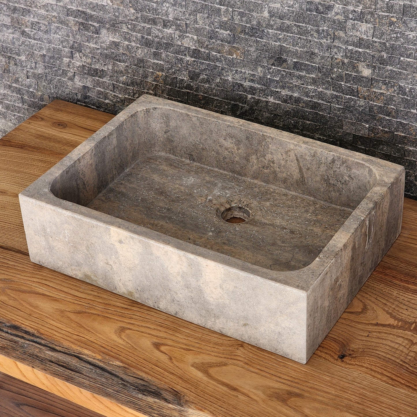 Norhew luxury rectangular silver travertine vessel sink with a honed grey-beige finish and solid block silhouette on a wooden vanity.