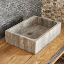 Switch Norhew luxury rectangular silver travertine vessel sink with a honed grey-beige finish and solid block silhouette on a wooden vanity. 3 image