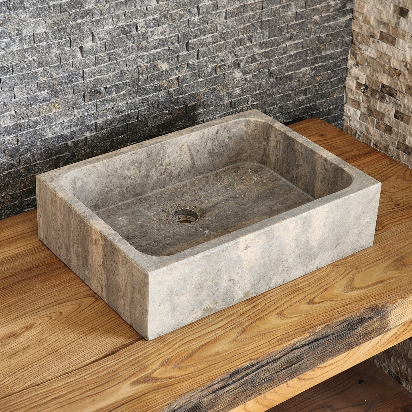 Norhew luxury rectangular silver travertine vessel sink with a honed grey-beige finish and solid block silhouette on a wooden vanity.