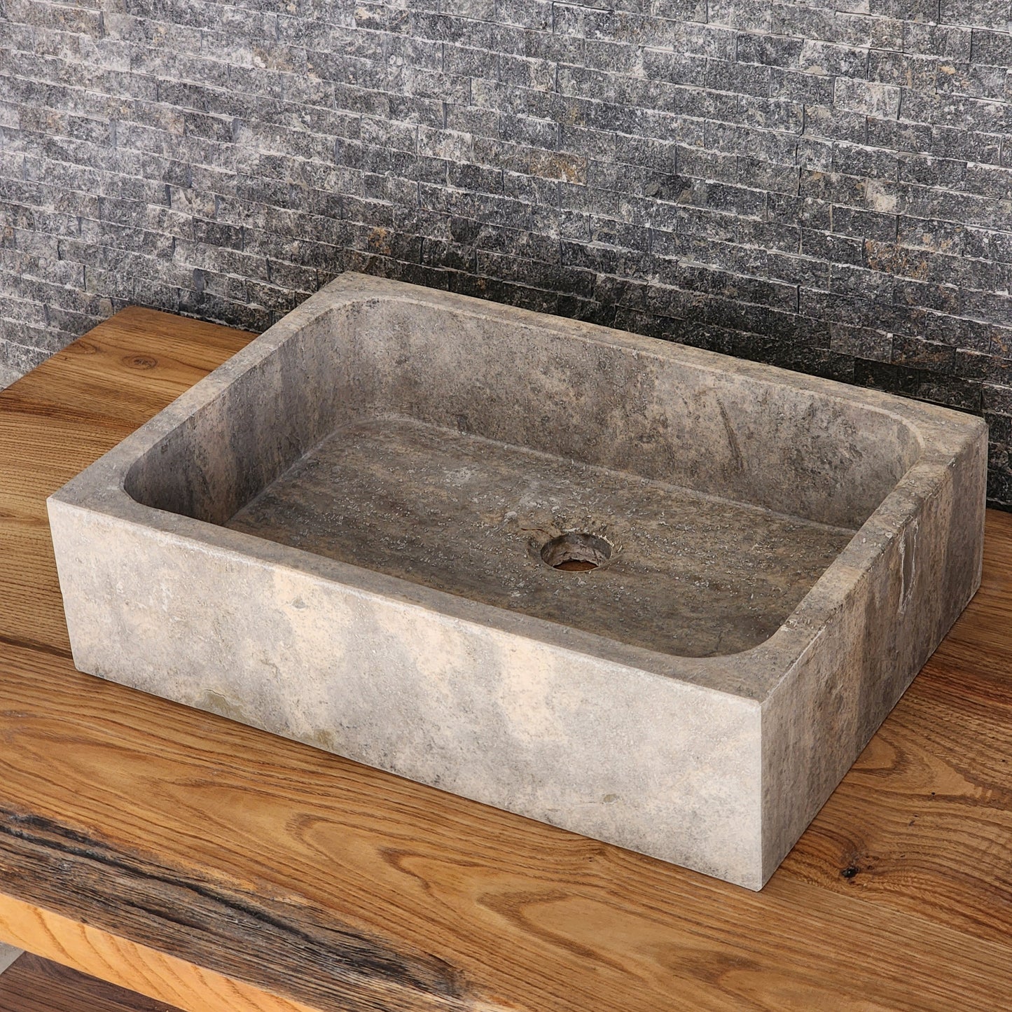 Norhew luxury rectangular silver travertine vessel sink with a honed grey-beige finish and solid block silhouette on a wooden vanity.