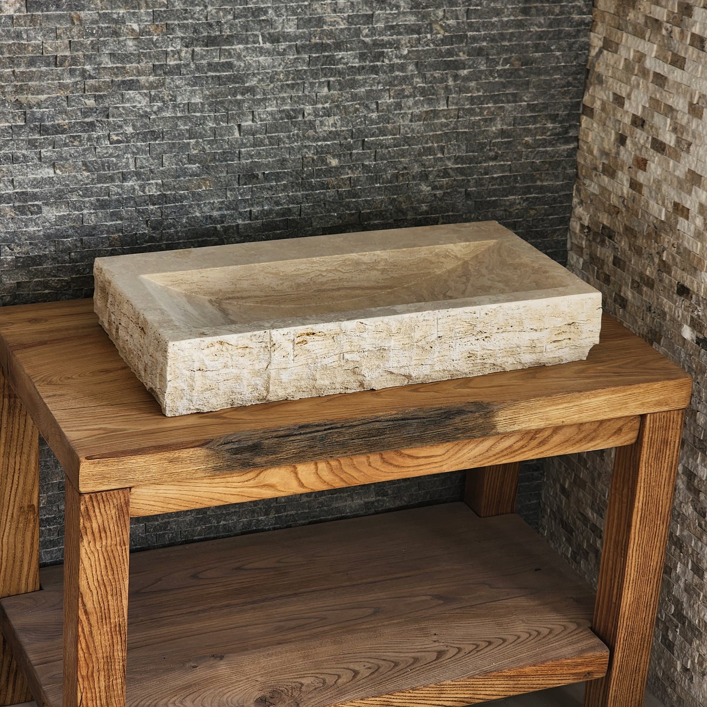Norhew luxury large rectangular travertine trough sink with a hand-chiseled raw exterior and a wide smooth interior on a wooden vanity.