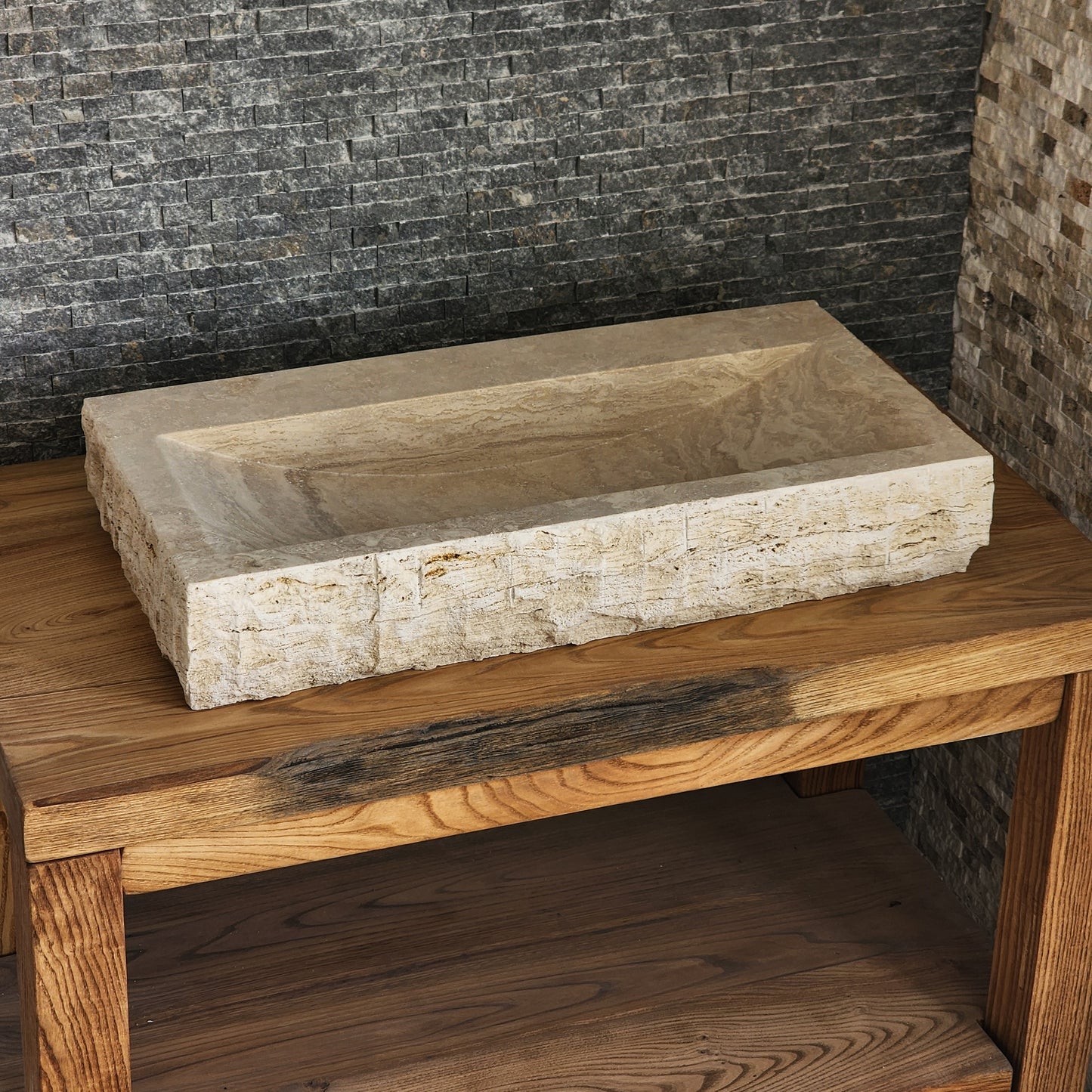 Norhew luxury large rectangular travertine trough sink with a hand-chiseled raw exterior and a wide smooth interior on a wooden vanity.