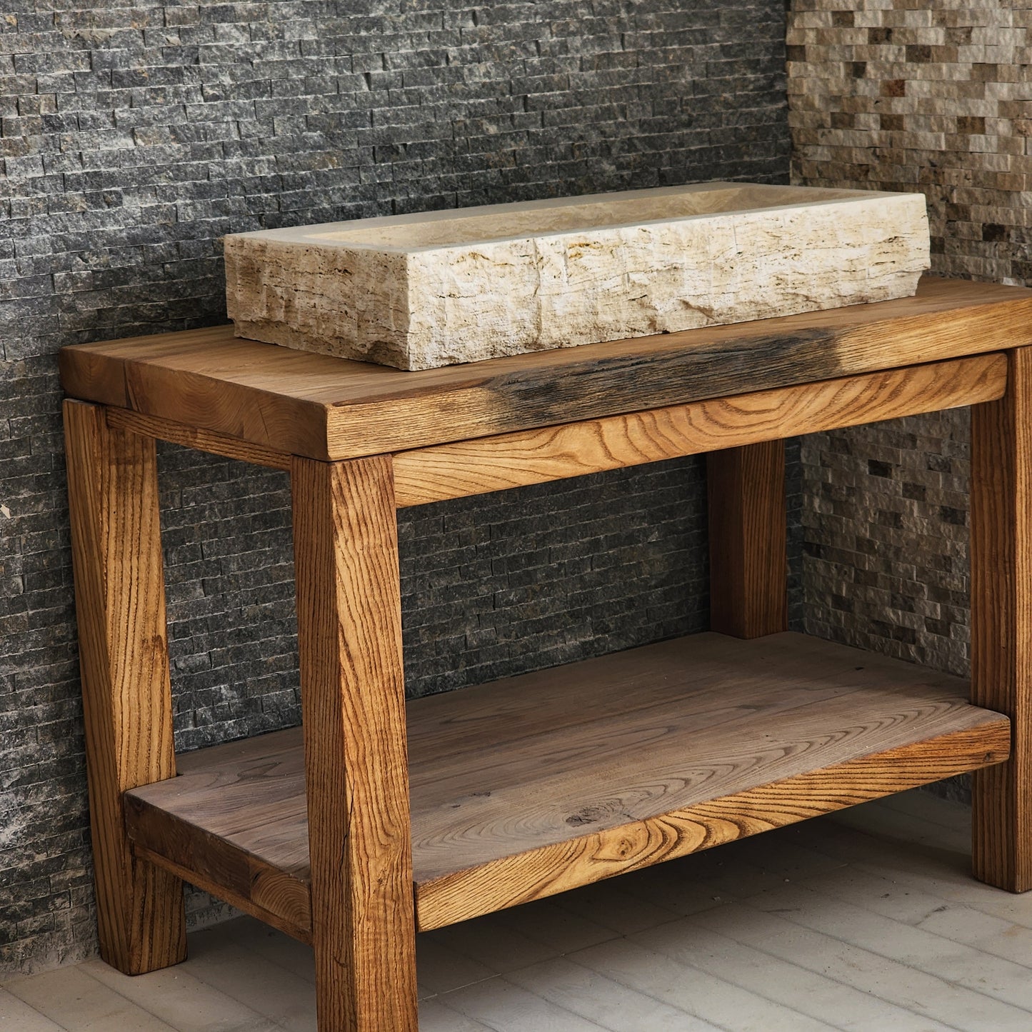 Norhew luxury large rectangular travertine trough sink with a hand-chiseled raw exterior and a wide smooth interior on a wooden vanity.